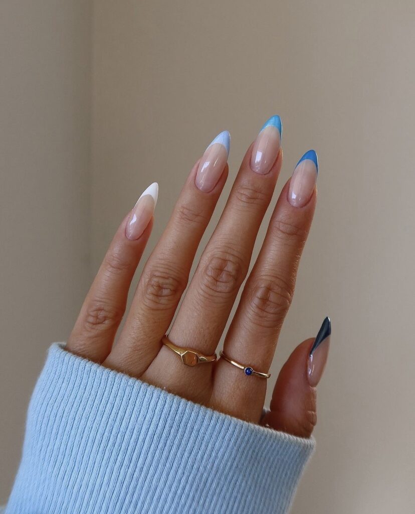 An image of nails with a soft gradient from clear to blue on stiletto tips.