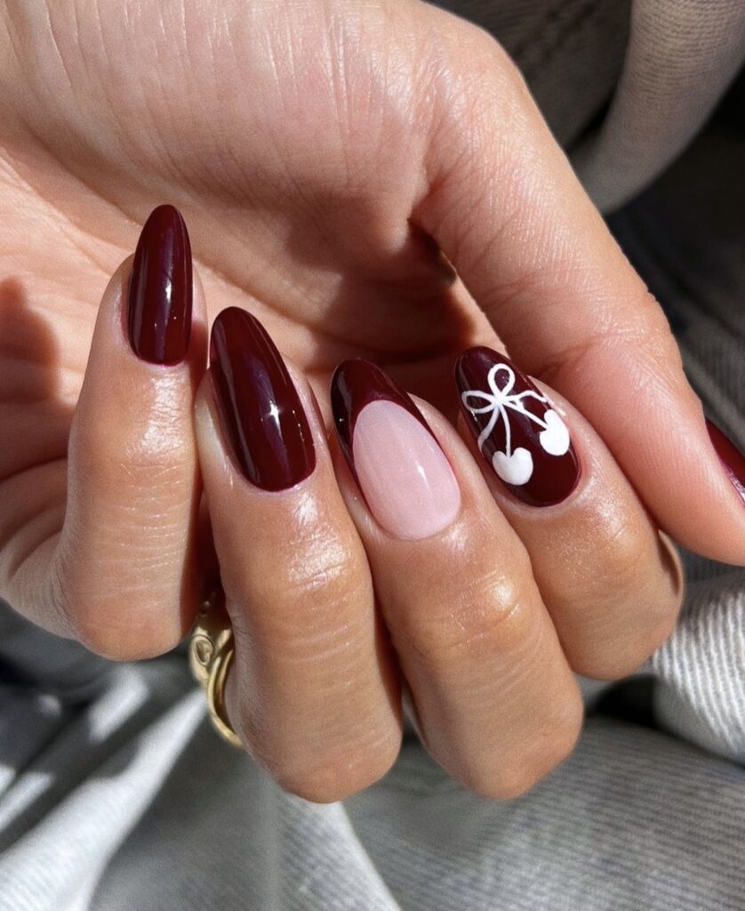 Deep burgundy nails with cute white cherry designs.