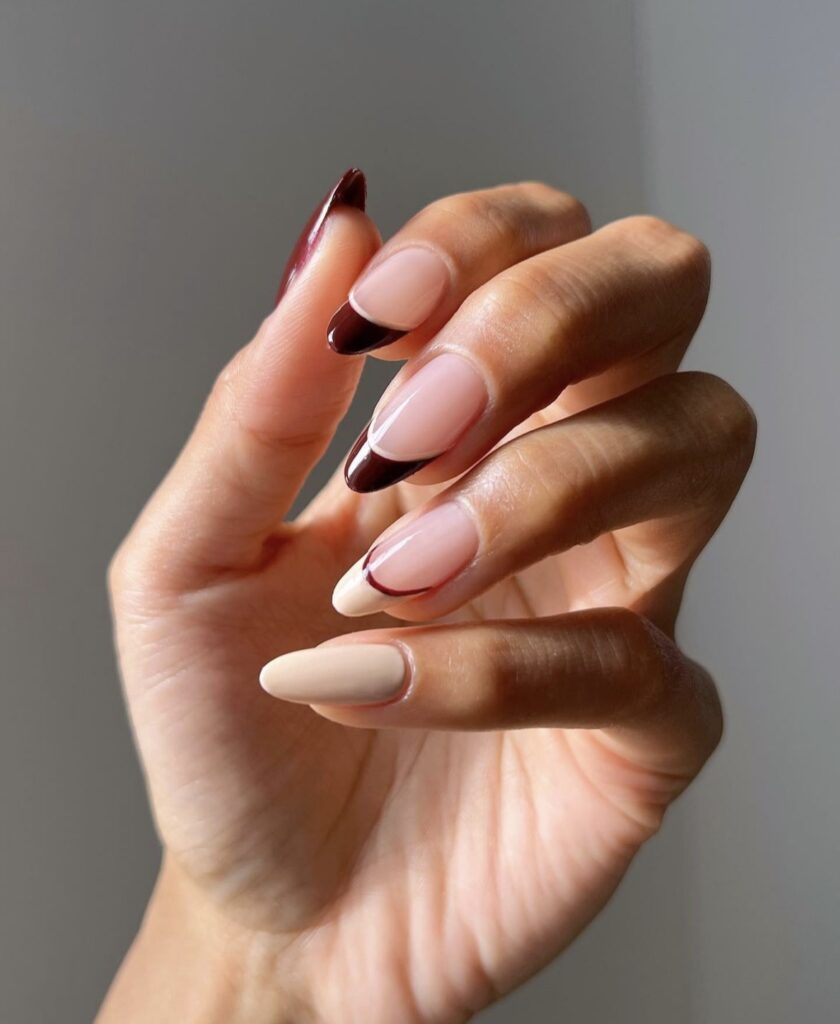 Mixed burgundy and beige nails with different designs on each finger.