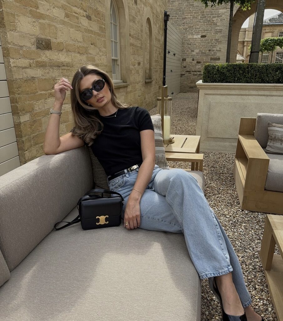 Elegant and relaxed outfit featuring light wash jeans, a simple black top, and black heels for a stylish city look.