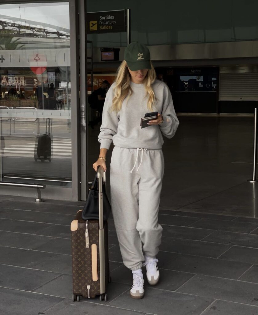 A cozy grey tracksuit paired with a baseball cap and white sneakers, perfect for sporty travel comfort.