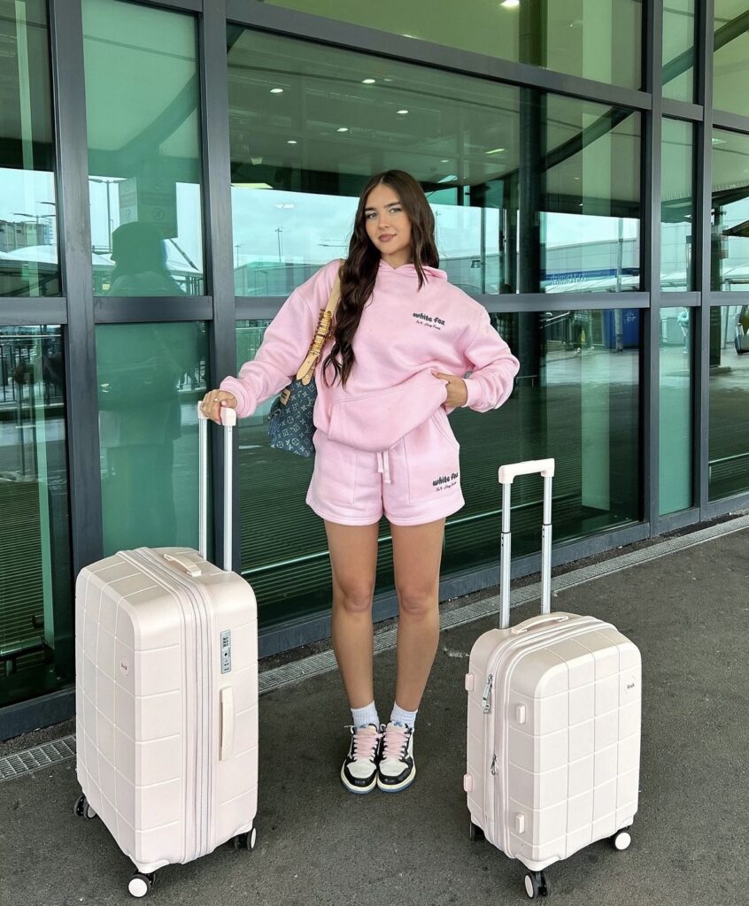 A vibrant pink hoodie and shorts set, styled with high-top sneakers.