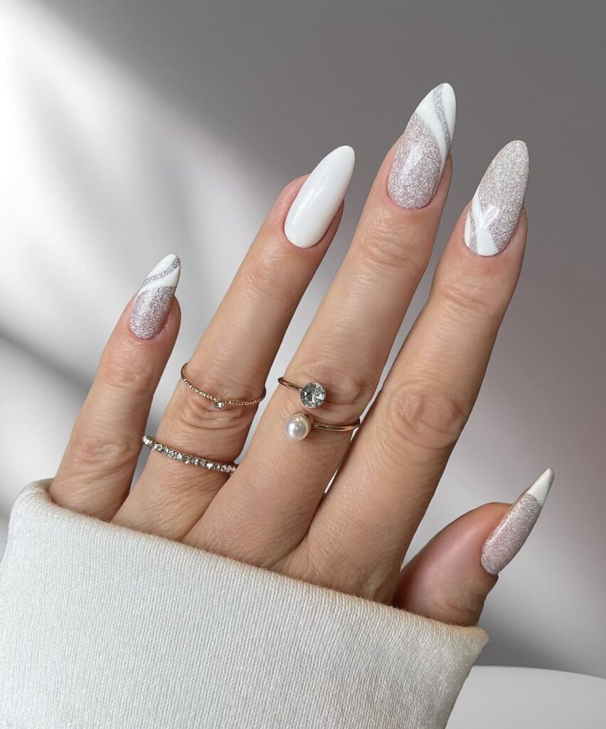 Simple winter nail design with pure white nails and glitter accents.