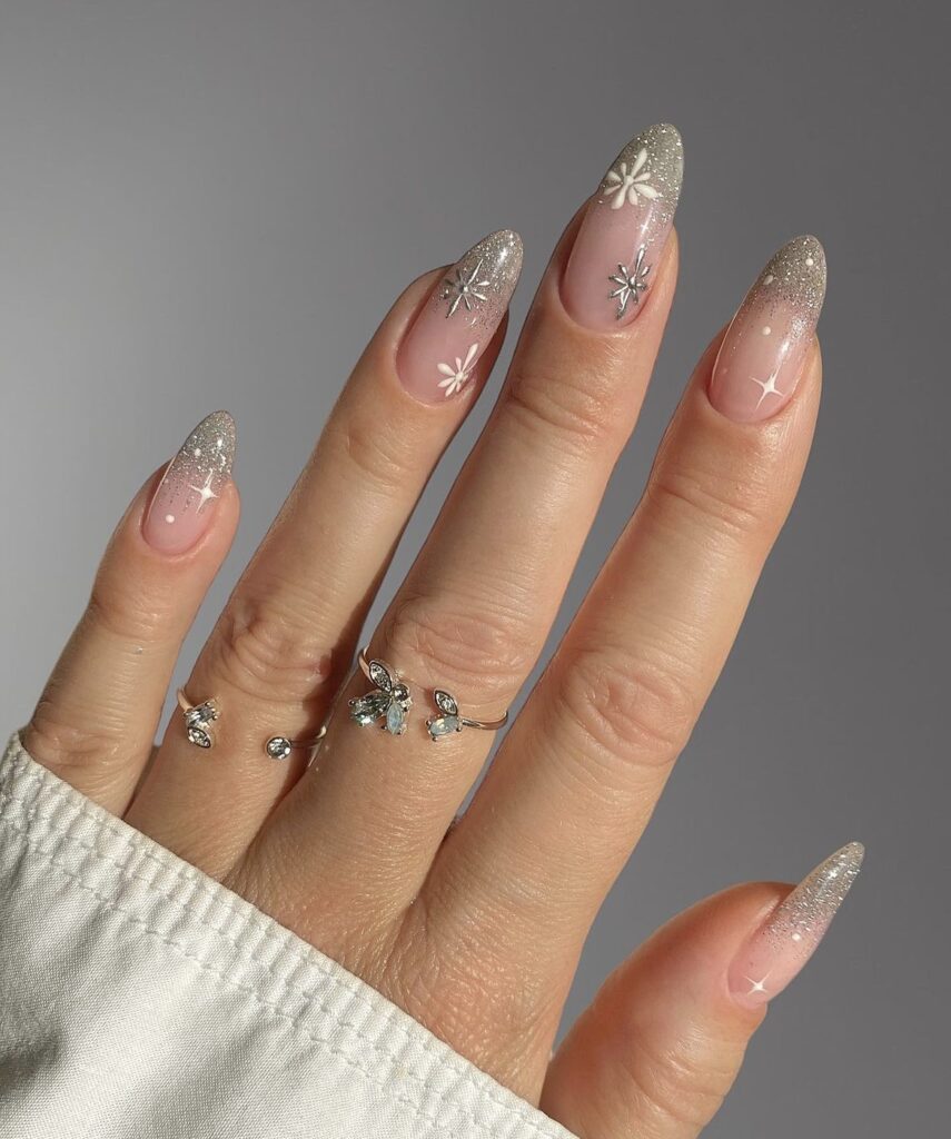 Festive winter nails with glittering silver tips on a clear base.